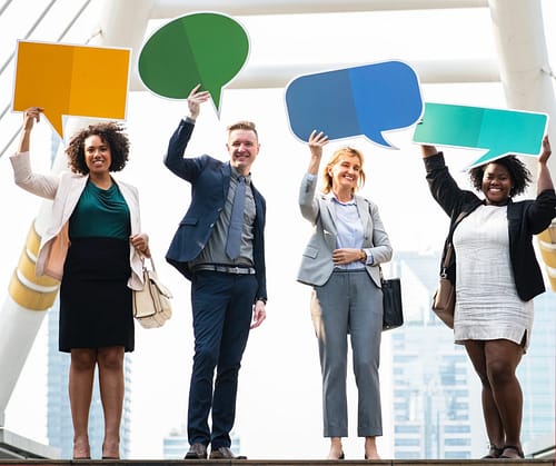 four business people holding up text box signs