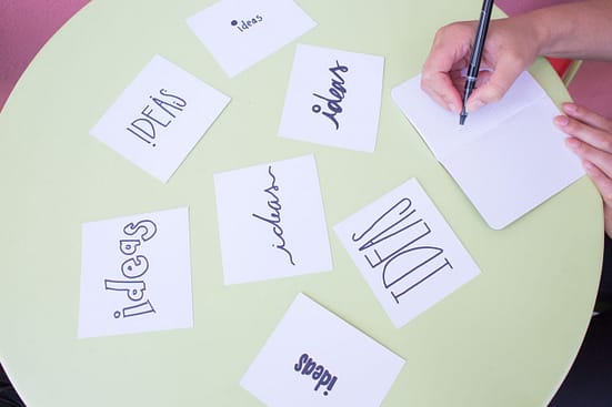 index cards on a table with various forms of the word "ideas" written on them